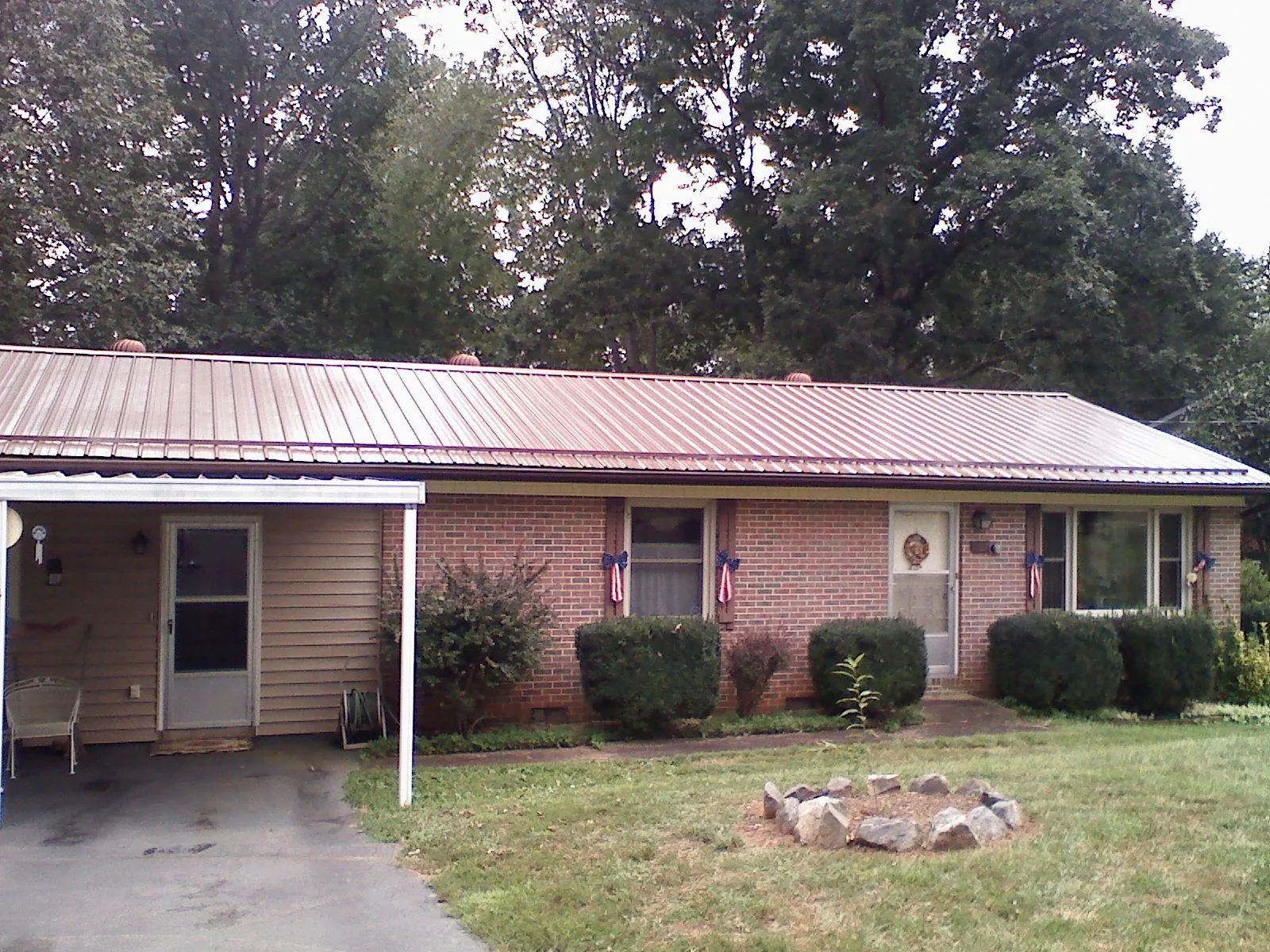 Bronze metal roof and carport on a brick ranch home — Roof Repair work by our crew in Pursglove